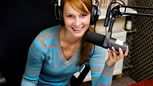Portrait of female dj working in front of a microphone on the ra